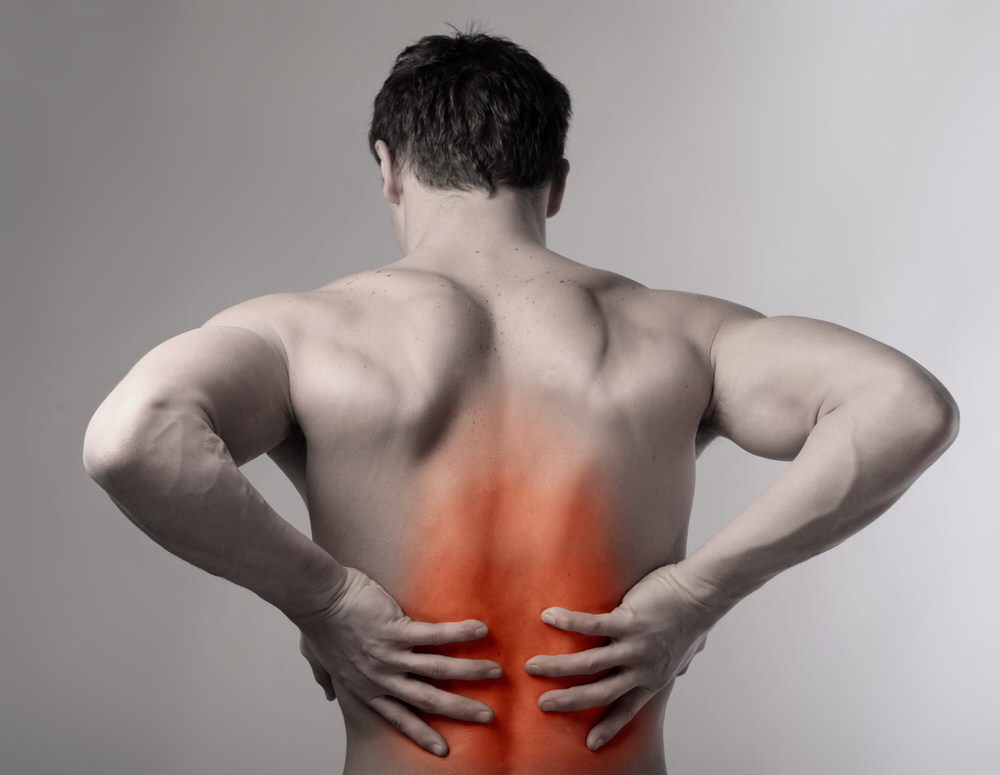 Athletic man holding painful lower back.